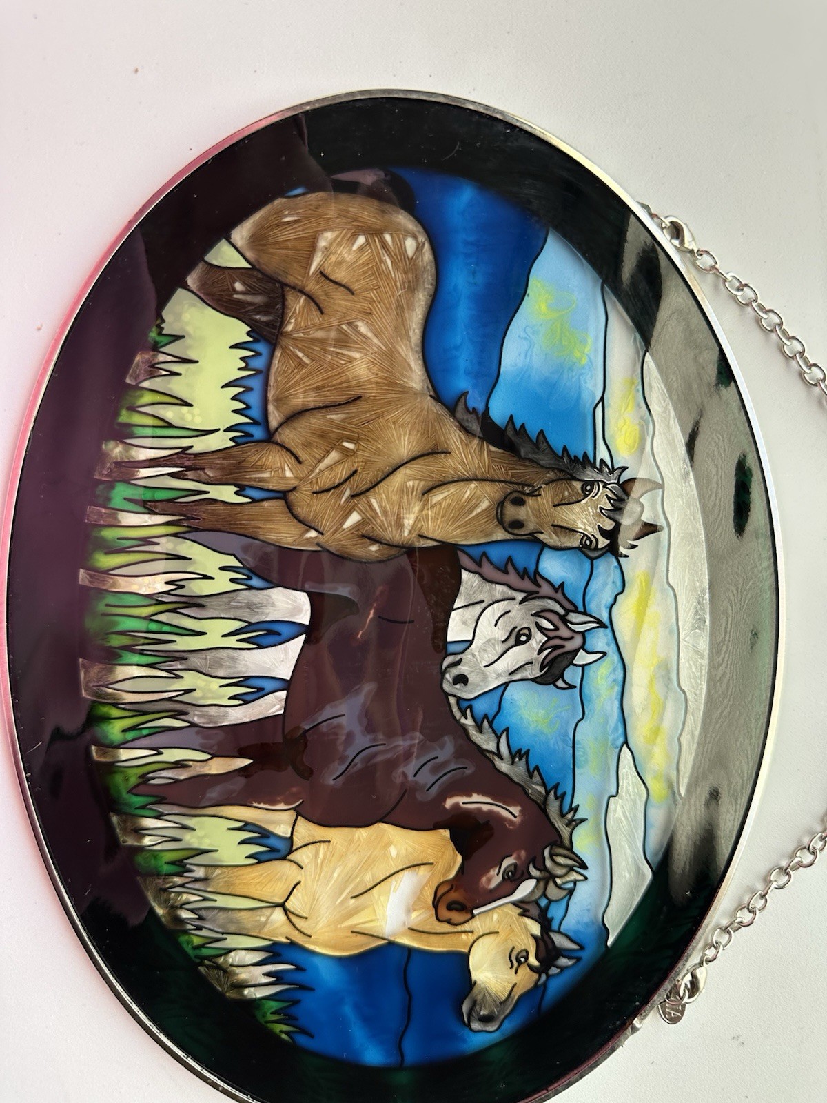 Amia branded suncatcher featuring a hand-painted glass design of running horses