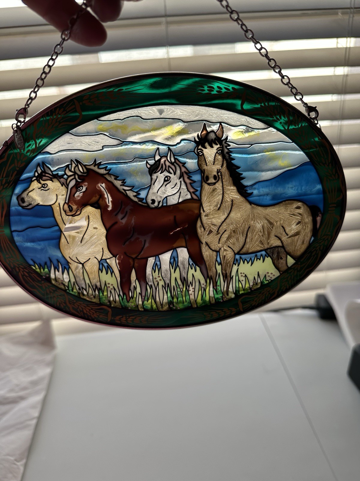 Amia branded suncatcher featuring a hand-painted glass design of running horses