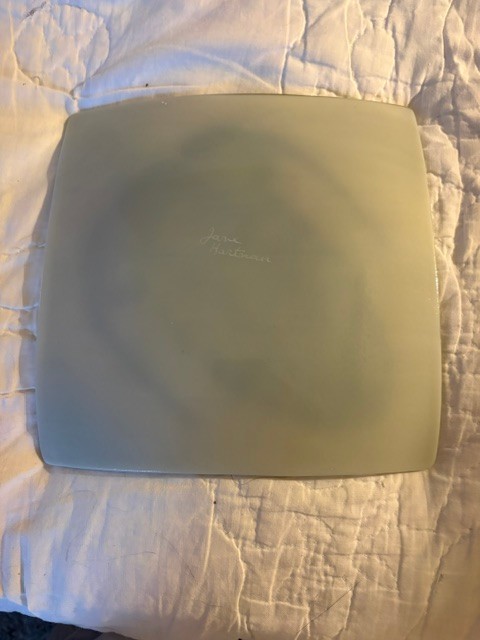 Handmade 8″ glass dish with trilobite on front signed by Jane Hartman on back